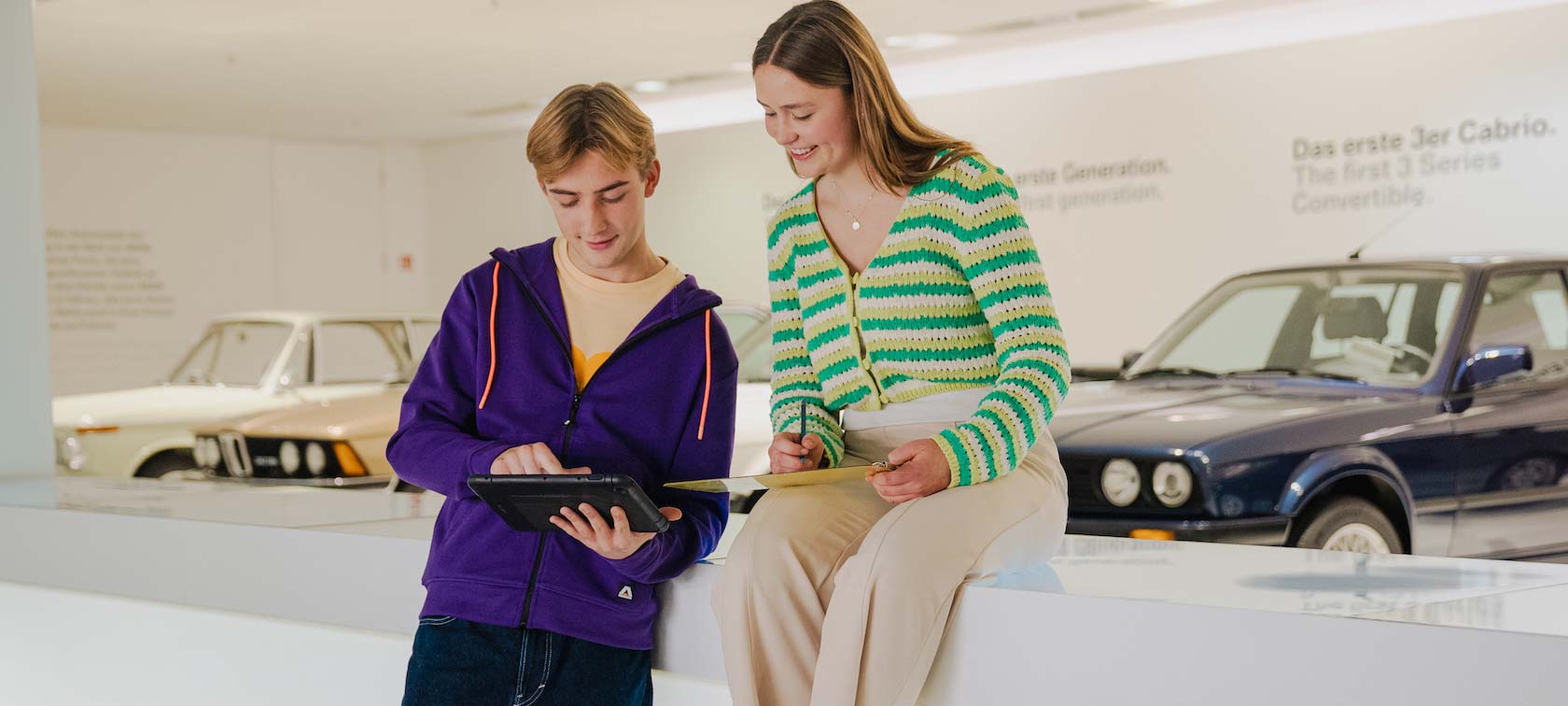 Two workshop participants look at their material on a tablet