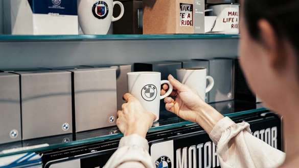mitarbeiterin stellt tasse in regal im bmw welt shop mitarbeiterin stellt tasse in regal im bmw welt shop