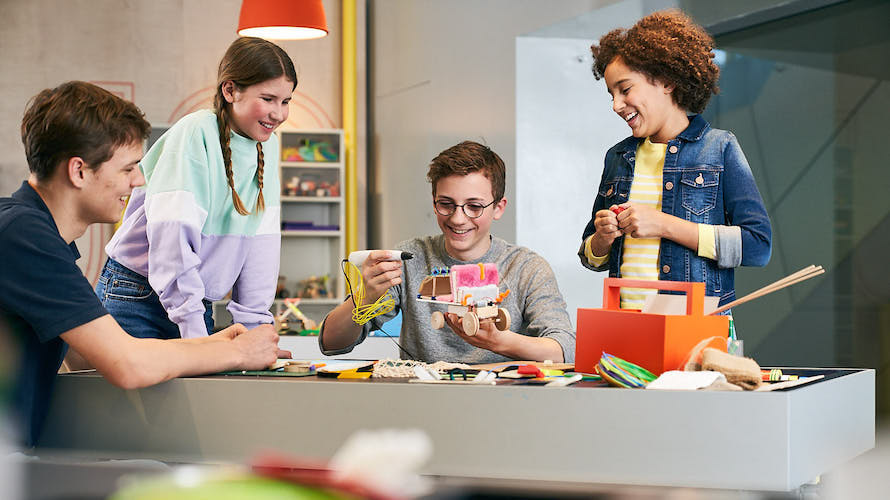 Children tinker with a futuristic car at the BMW creative workshop