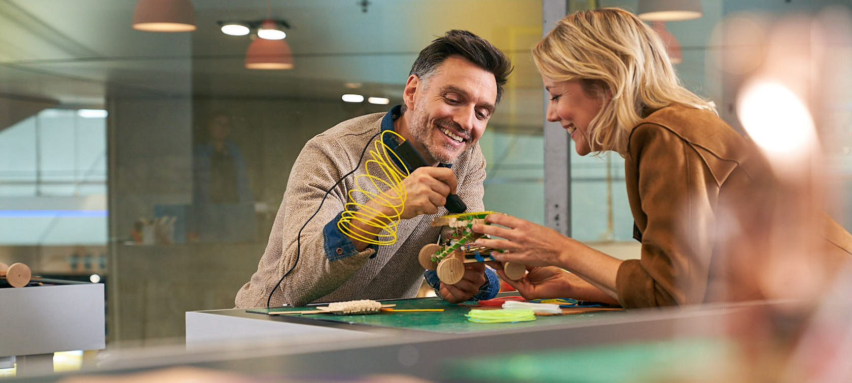 Man and woman tinkering together on a car model